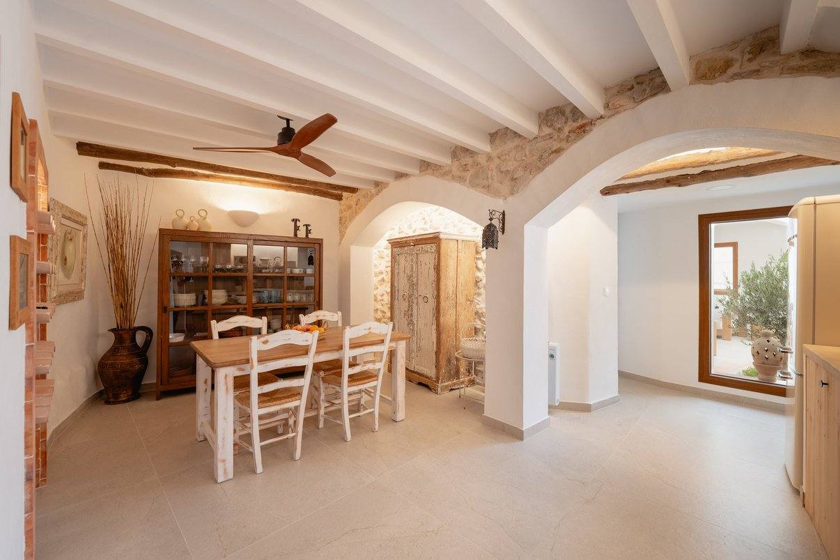El comedor bajo los arcos de piedra, con la alacena de la vajilla.