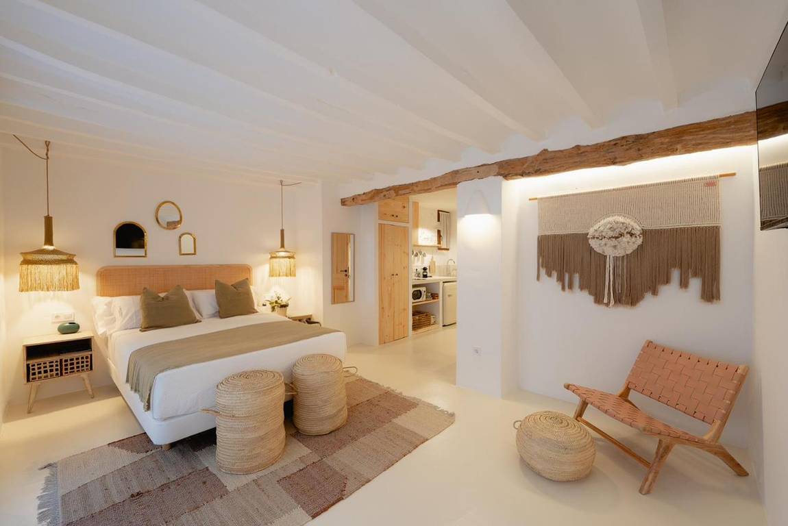 Blanqueta: cama con cabecero de ratán y tapiz de macramé.