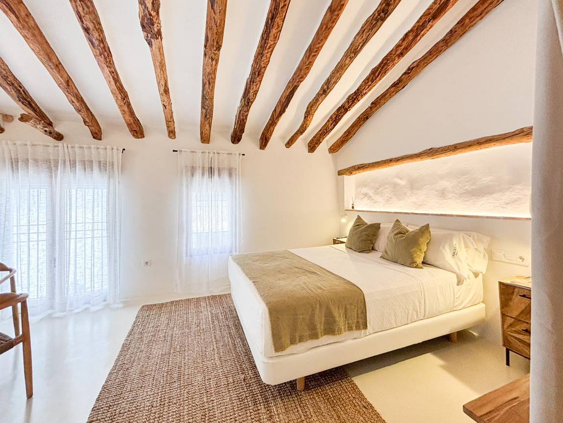 Manzanilla, dormitorio principal: hornacina sobre la cama y vigas de madera.